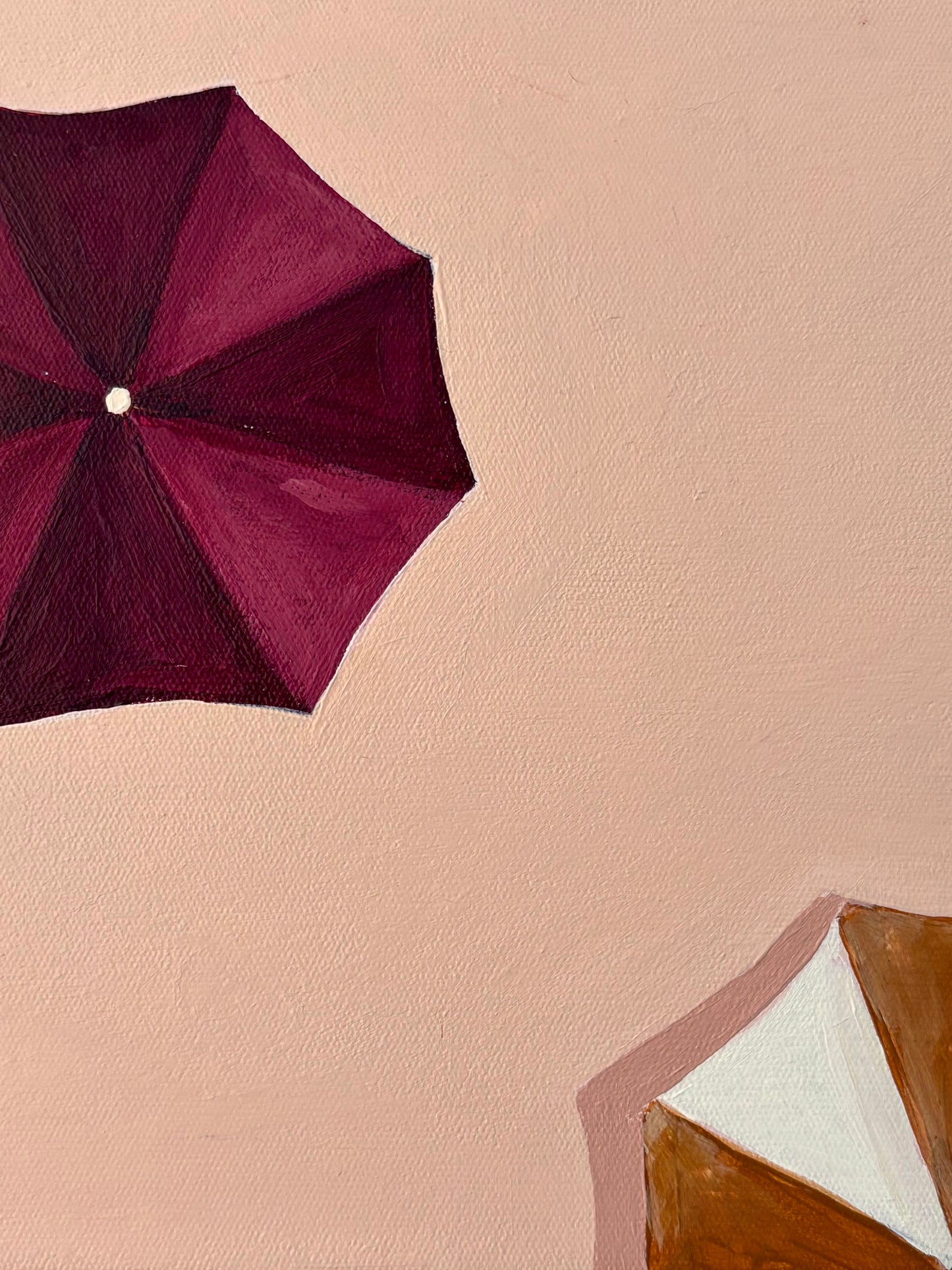 Framed artwork with Ariel view of burgundy and mustard umbrellas. Peach background.