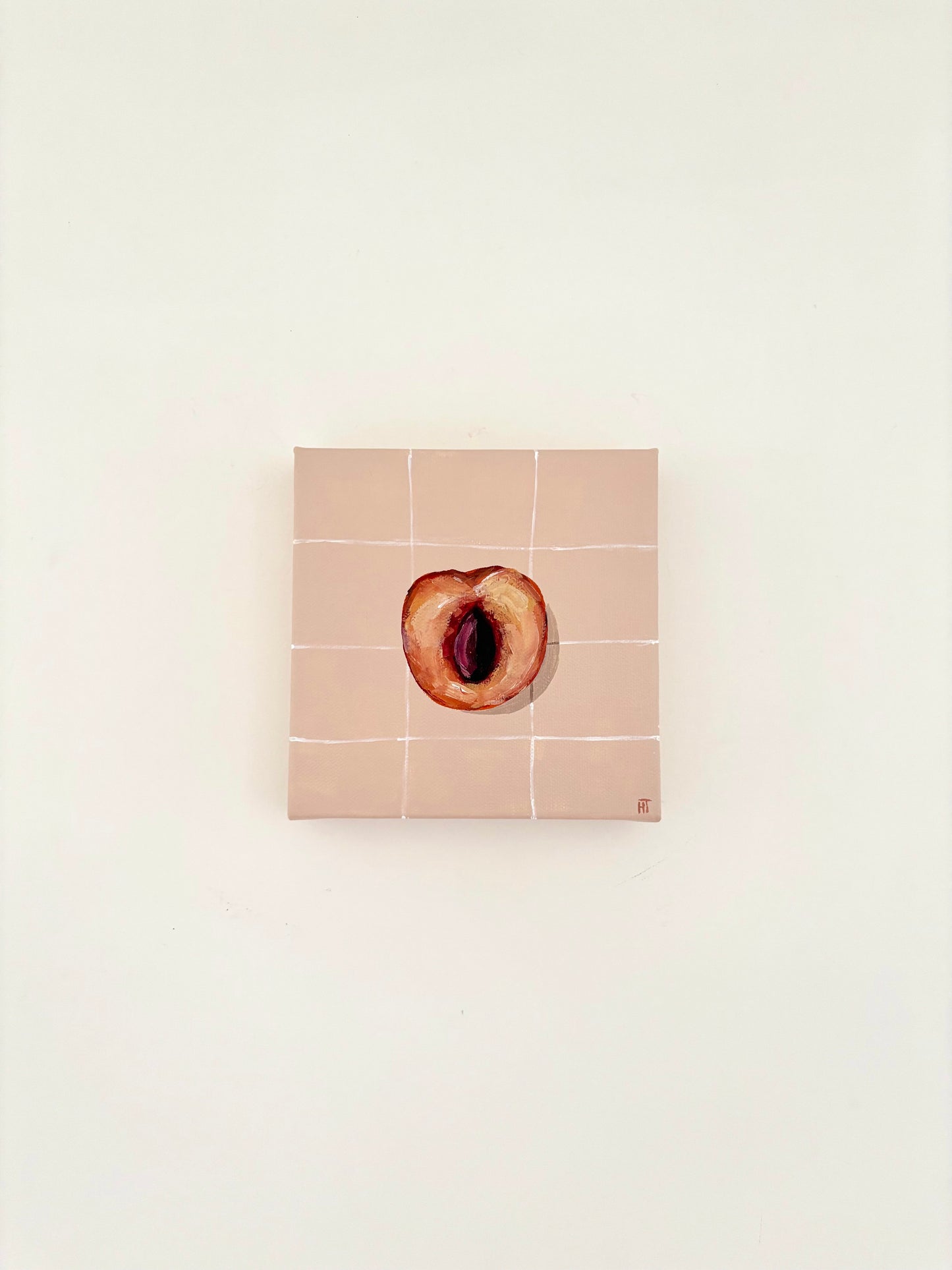 Painted halved peach on pale peach tiled background.