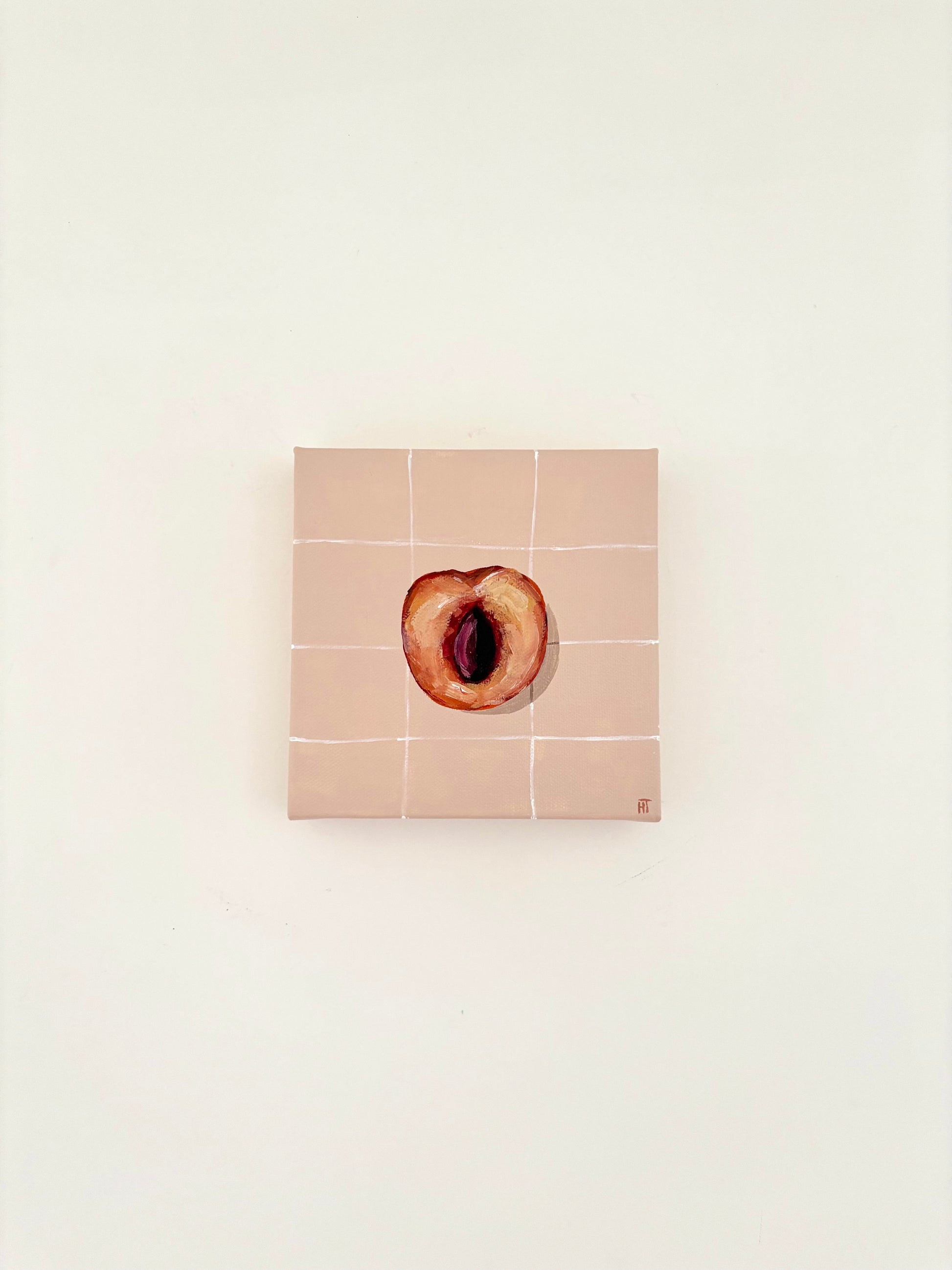 Painted halved peach on pale peach tiled background.