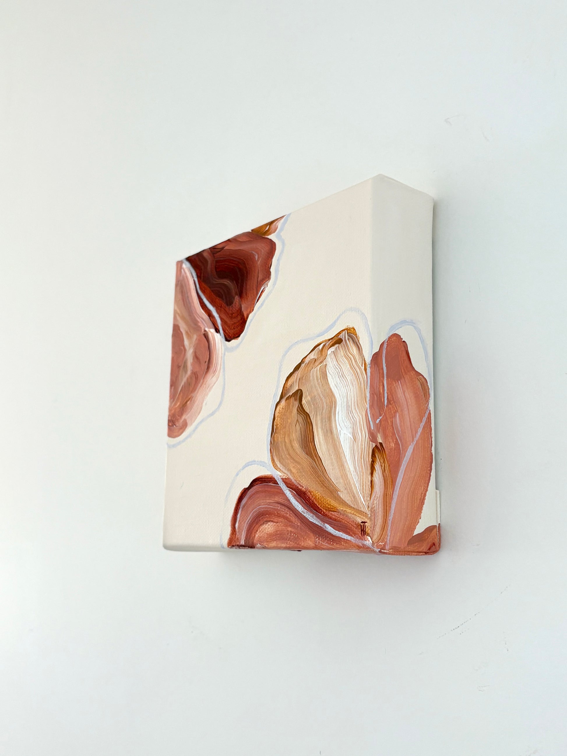 Painting of abstract flowers. Petals are warm browns and pinks and are placed in two corners of the canvas and wrap around the side of it. 