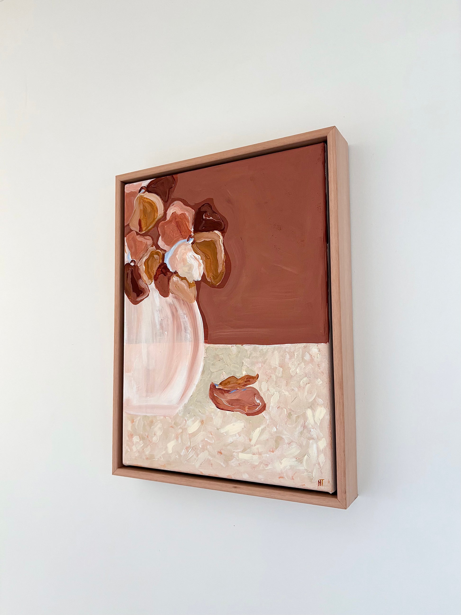 Abstract painting of warm brown and pink flowers in a vase on a brown and cream background. The bottom halve of the background is textured cream colours with two fallen petals. 