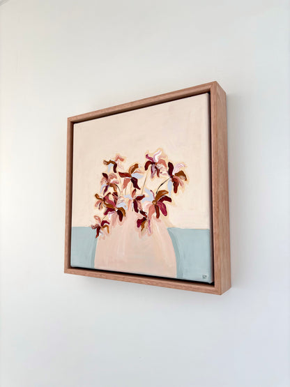 Painting of burgundy brown and blue abstract flowers in a pale pink vase with a cream and pale blue background. 