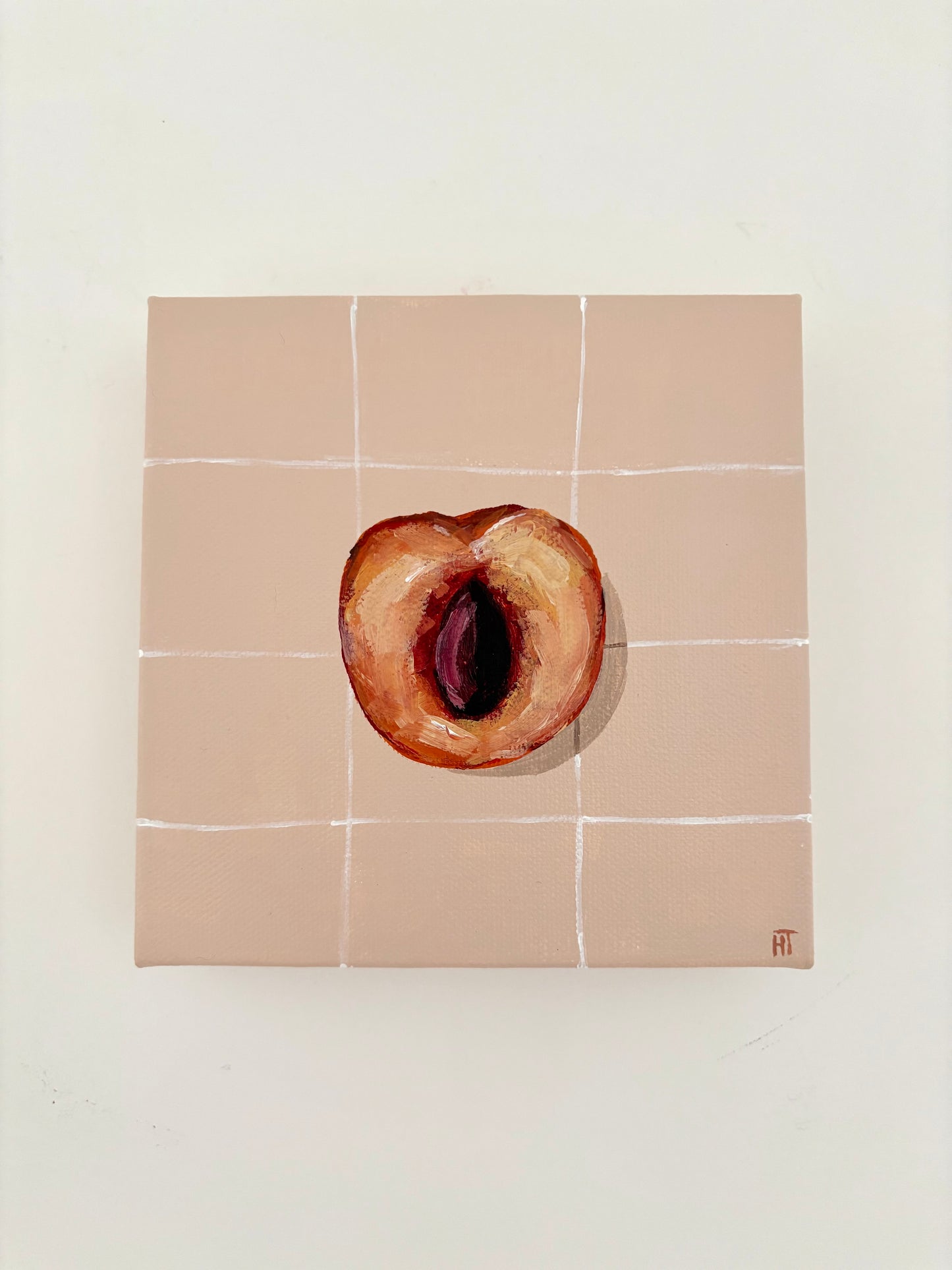 Painted halved peach on pale peach tiled background.
