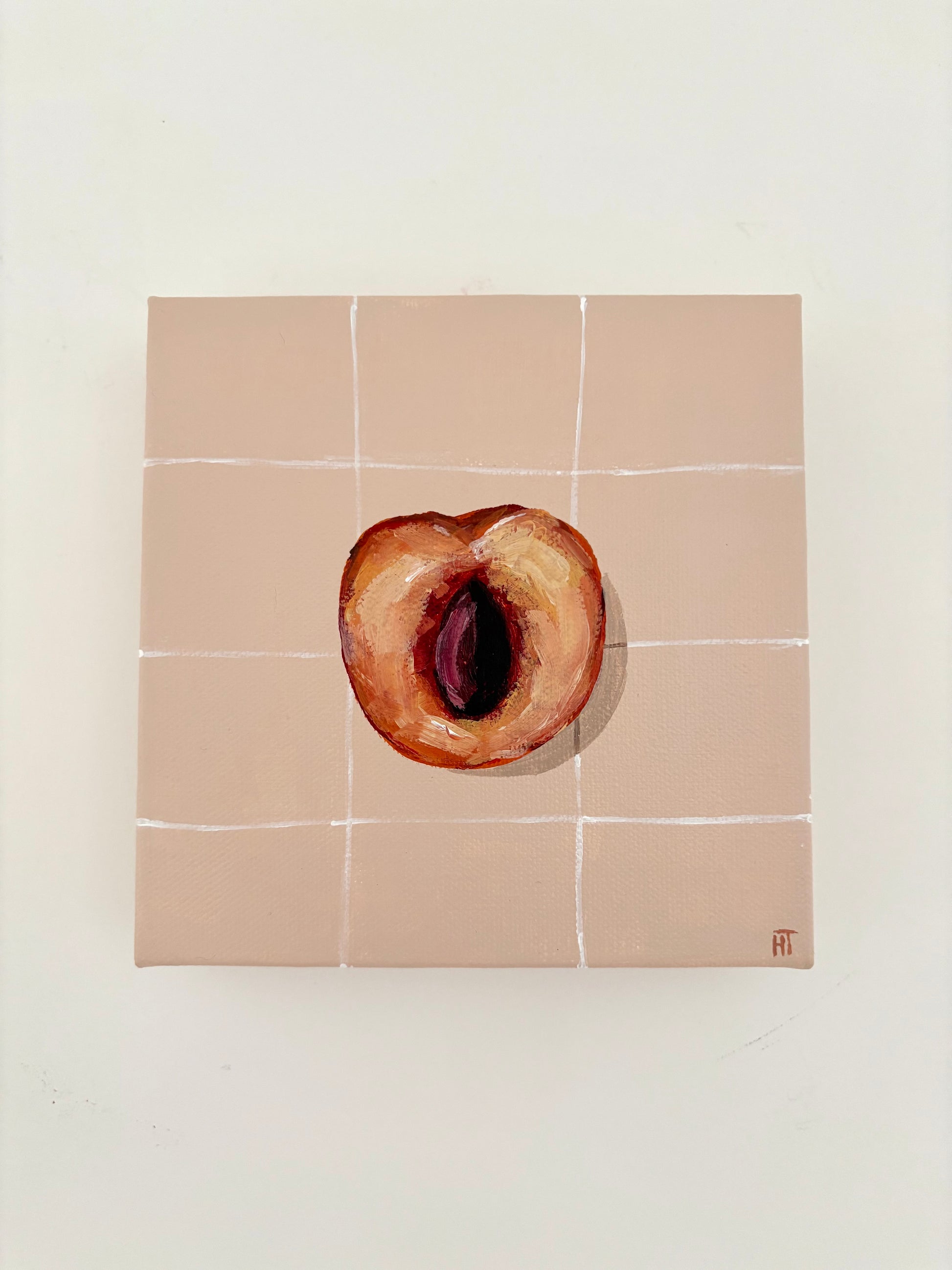 Painted halved peach on pale peach tiled background.