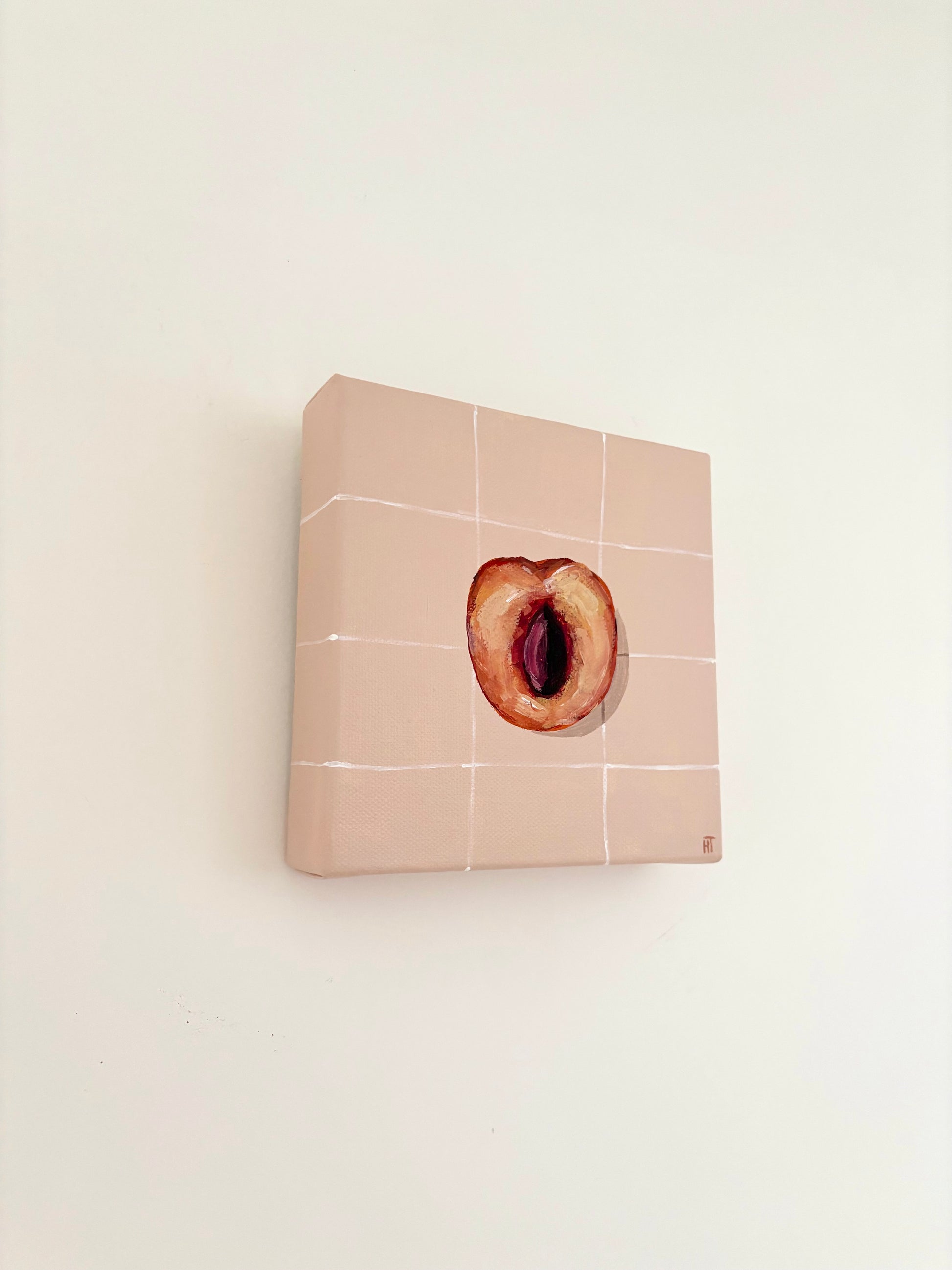 Painted halved peach on pale peach tiled background.