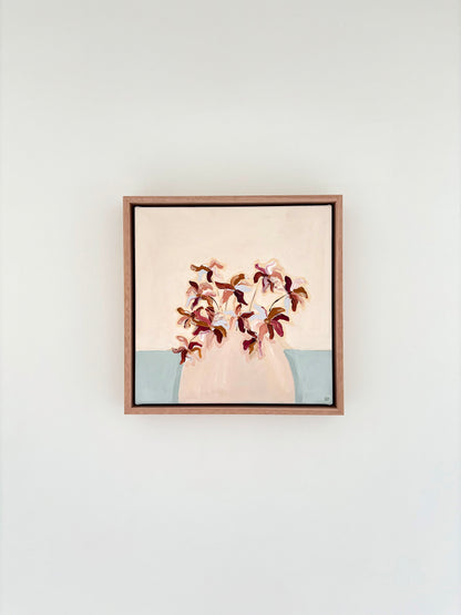 Painting of burgundy brown and blue abstract flowers in a pale pink vase with a cream and pale blue background. 