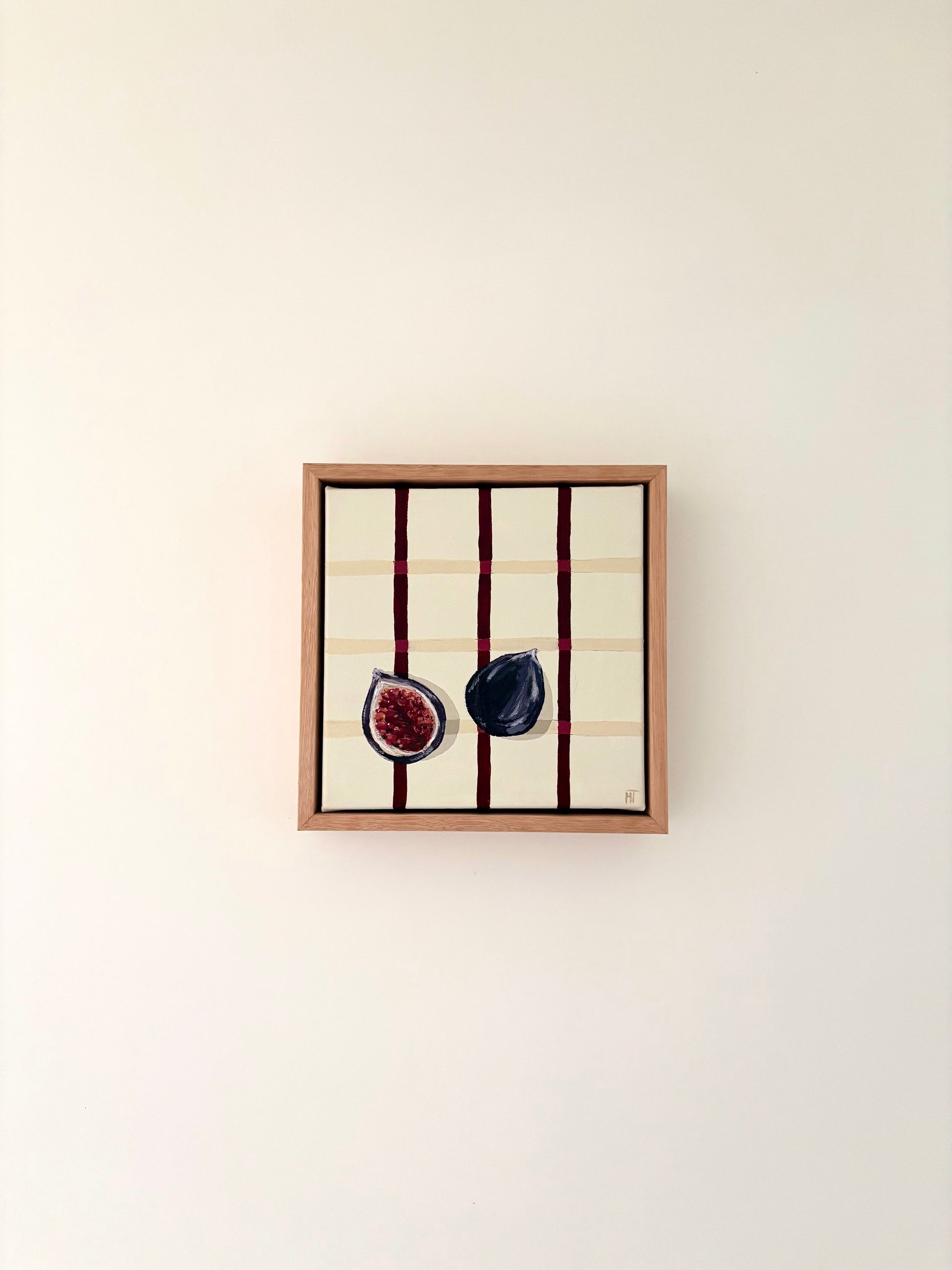 Painting of a halved dark fig on a cream checkered background with burgundy lines.
