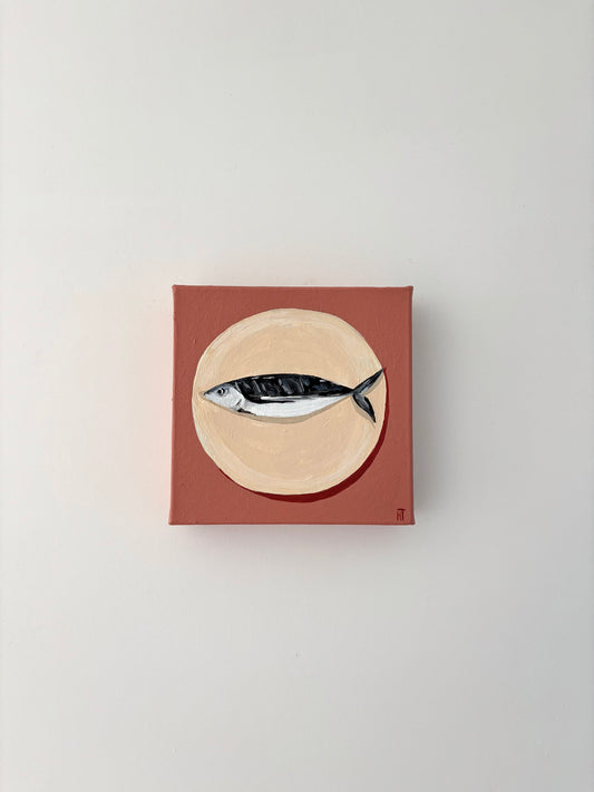Painting of a fish on a beige circle plate with a dusty pink background.